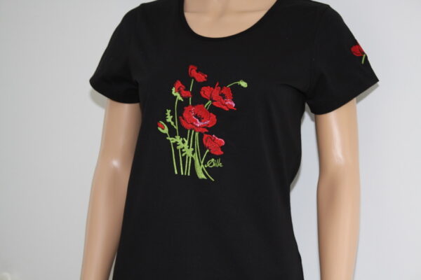T-shirt noir brodé avec des coquelicots rouges et verts, mettant en valeur un design floral.