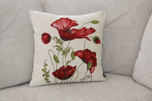 Coussin en lin illustré de coquelicots rouges, signé Sqille, sur un canapé beige.