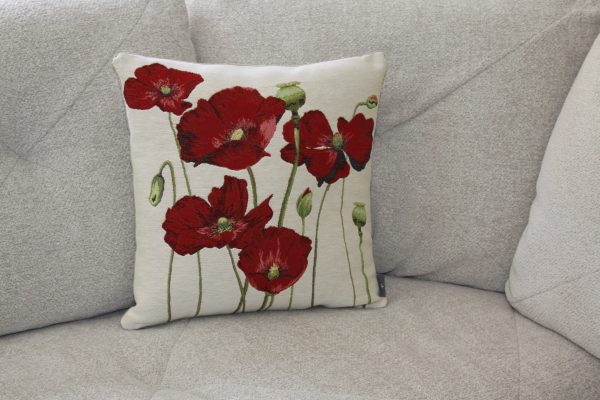 Coussin brodé représentant des coquelicots rouges sur fond beige, idéal pour une touche florale dans un intérieur chic.