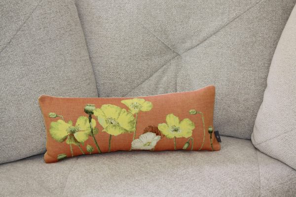 Coussin rectangulaire en tissu jacquard orange orné de motifs floraux de coquelicots jaunes et blancs.