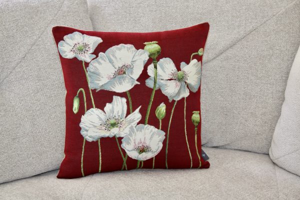 Coussin brodé représentant des coquelicots blancs sur un fond rouge, fabriqué en tissu jacquard français.