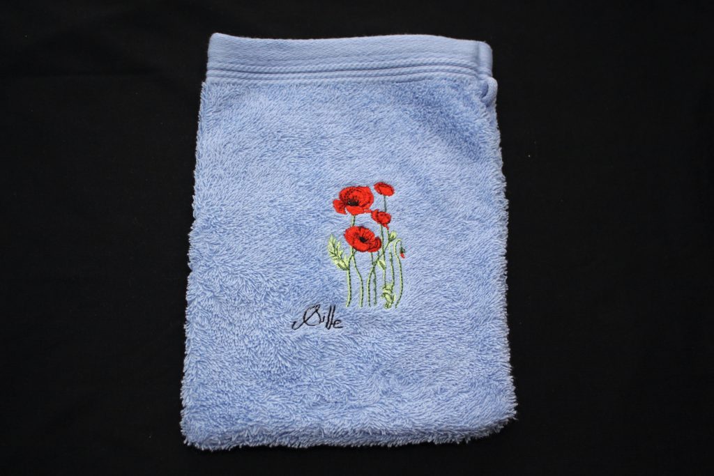 Blue washcloth with poppy embroidery, made in France by artisans.