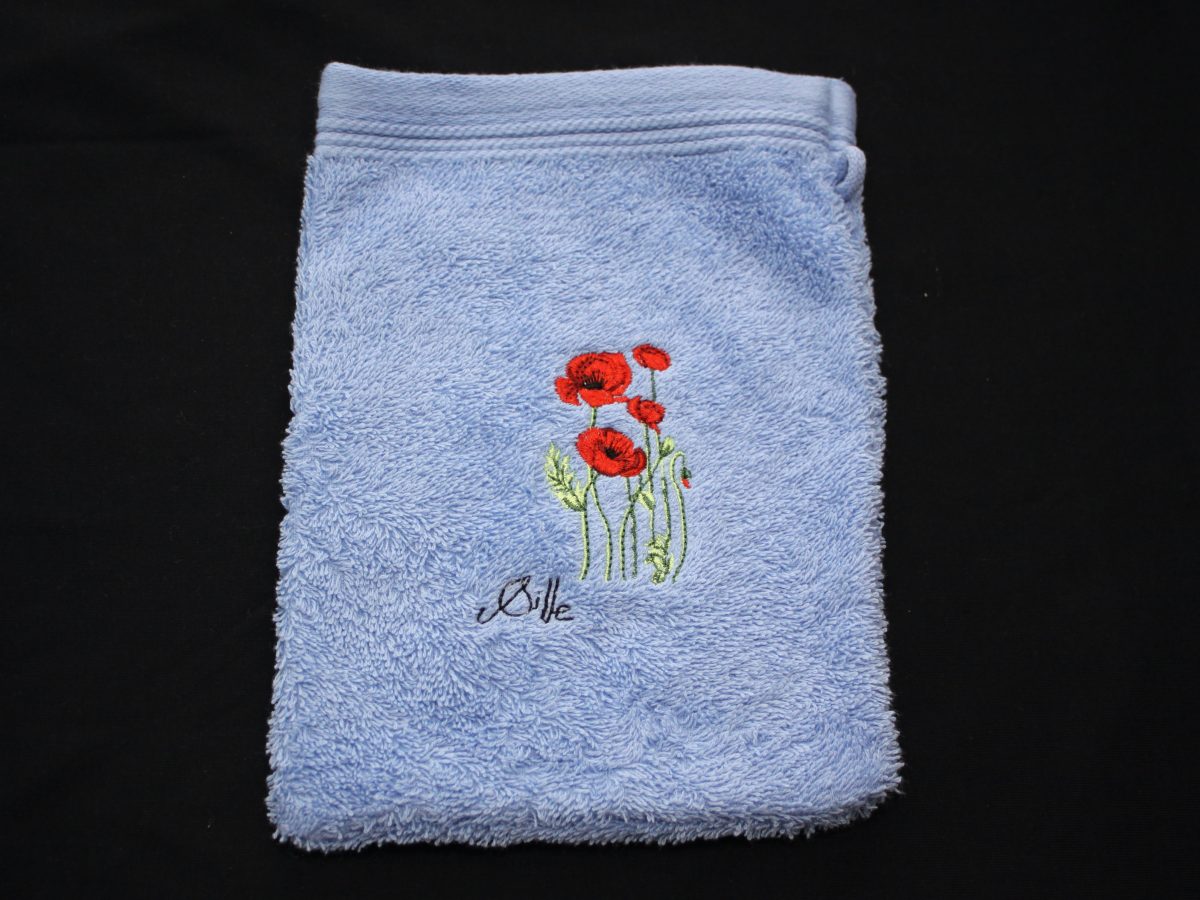 Gant de toilette bleu avec broderie de coquelicots, fabriqué en France par des artisans.