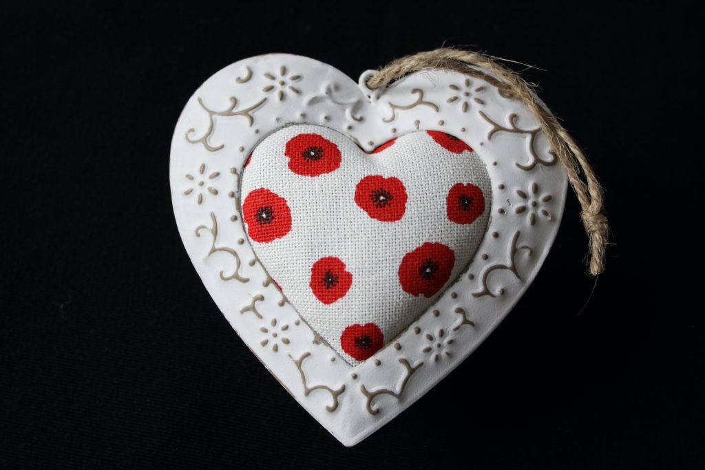 Cœur décoratif en métal et tissu avec motifs de coquelicots rouges, artisanal et unique.