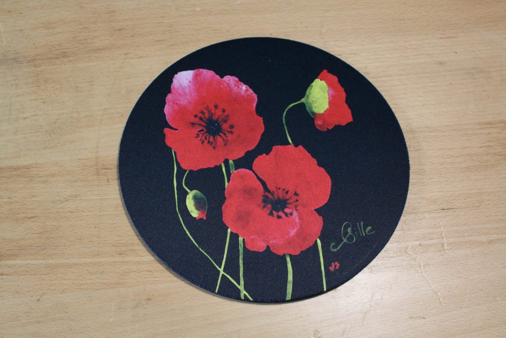 Dessous de plat rond avec motif de coquelicots rouges sur fond noir, création artisanale de Poppies Shop à Bayeux.