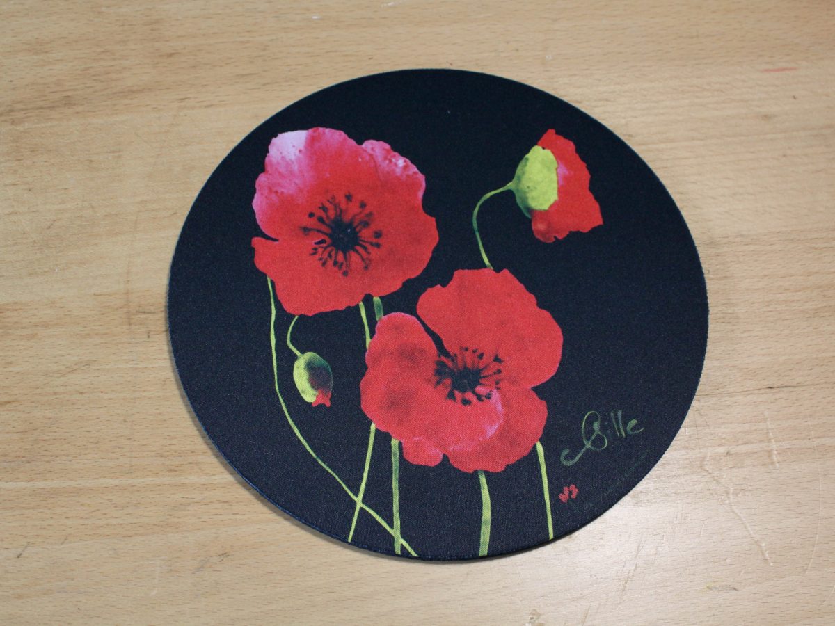 Dessous de plat rond avec motif de coquelicots rouges sur fond noir, création artisanale de Poppies Shop à Bayeux.