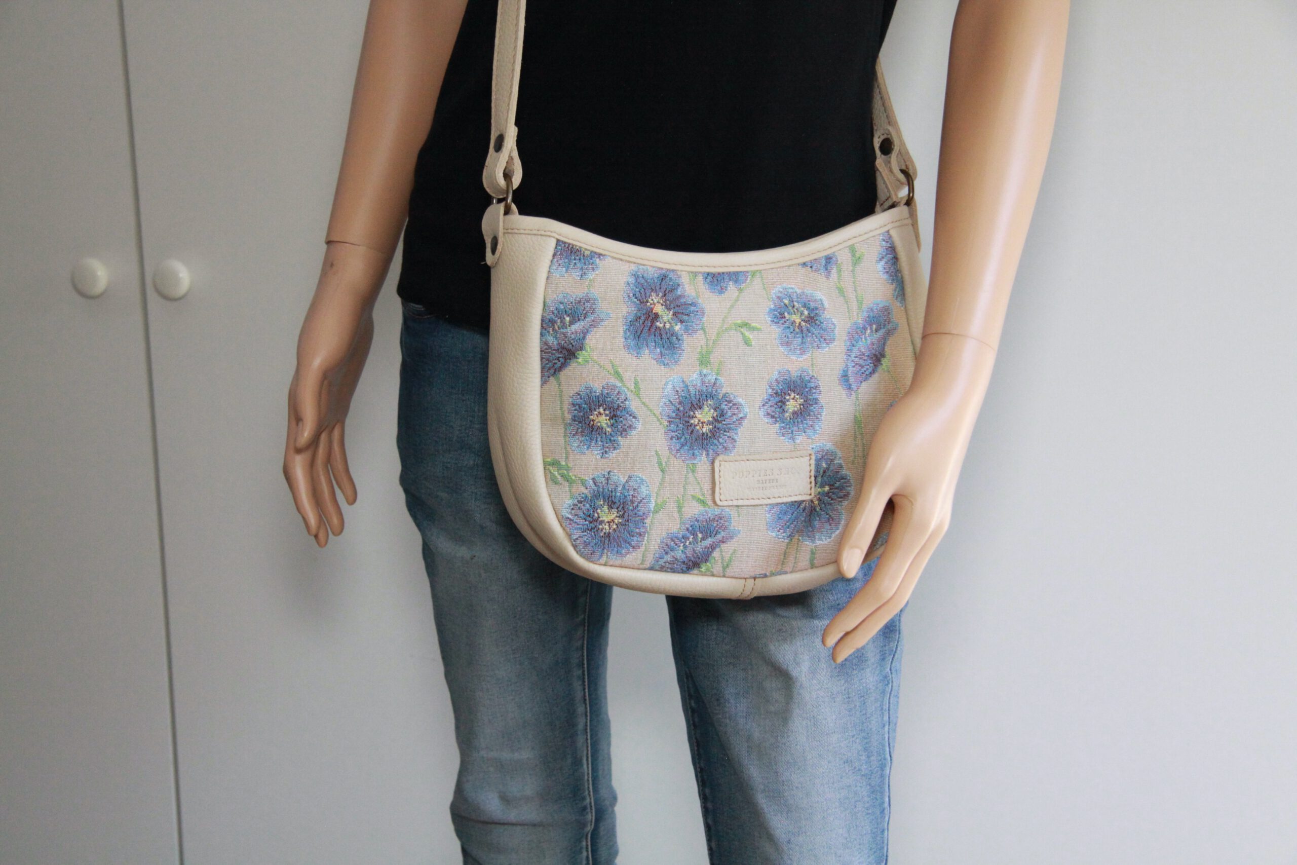 Sac demi-lune avec motifs floraux, fabriqué en tissu jacquard. Artisanat français. Présenté sur un mannequin.
