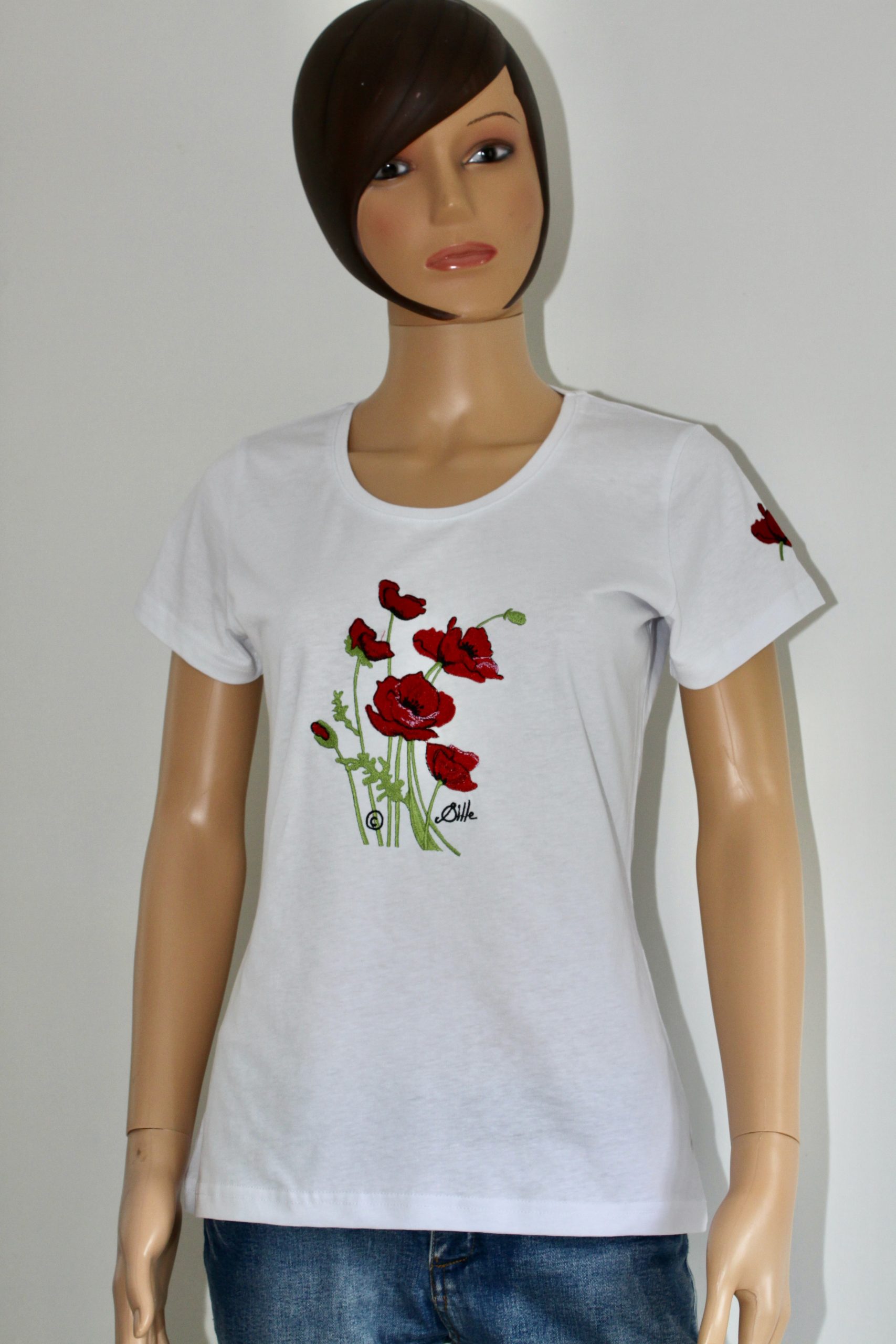 T-shirt blanc avec broderie de coquelicots sur le devant, présenté sur un mannequin.