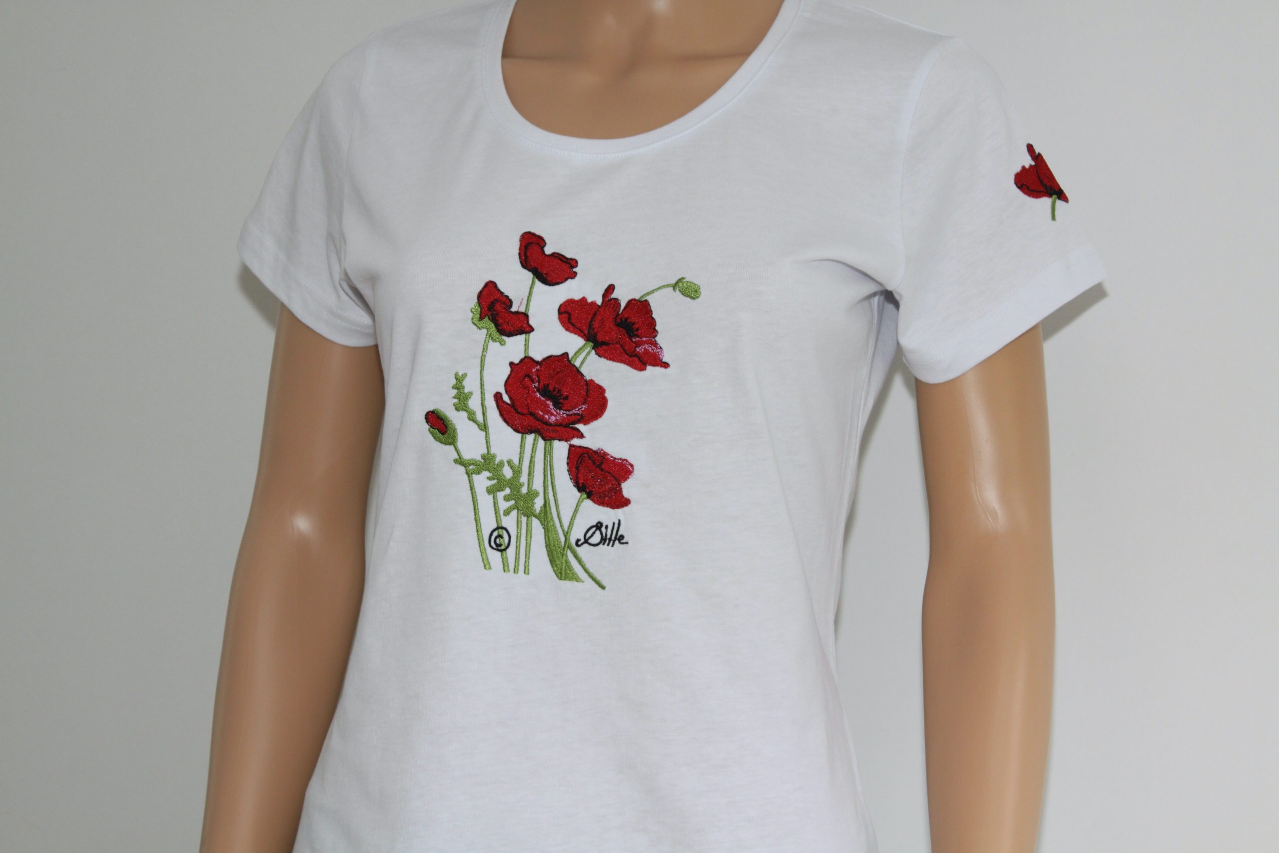 T-shirt blanc avec broderie de coquelicots rouges, disponible chez Poppies Shop à Bayeux.
