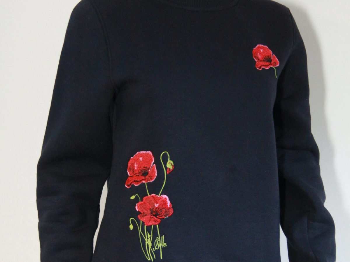 Sweat brodé bleu marine avec motifs de coquelicots, disponible à Poppies Shop, boutique d'artiste à Bayeux.