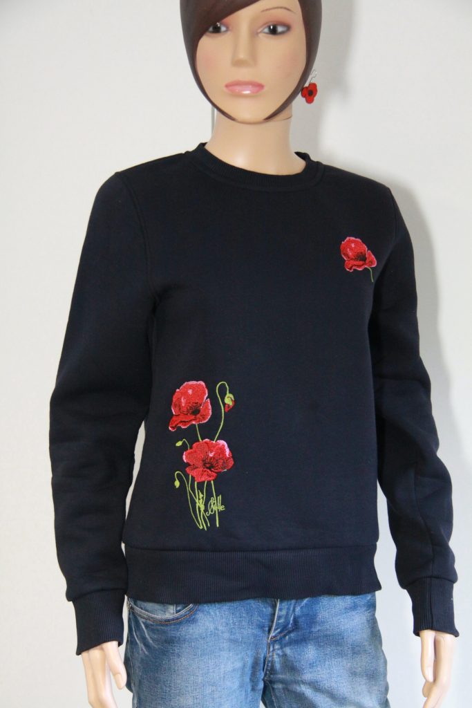 Sweat brodé bleu marine avec motifs de coquelicots, disponible à Poppies Shop, boutique d'artiste à Bayeux.