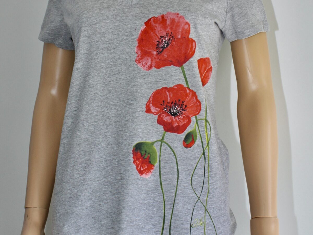 T-shirt gris à col V orné de motifs de coquelicots rouges sur le côté. Parfait pour un style floral et décontracté.