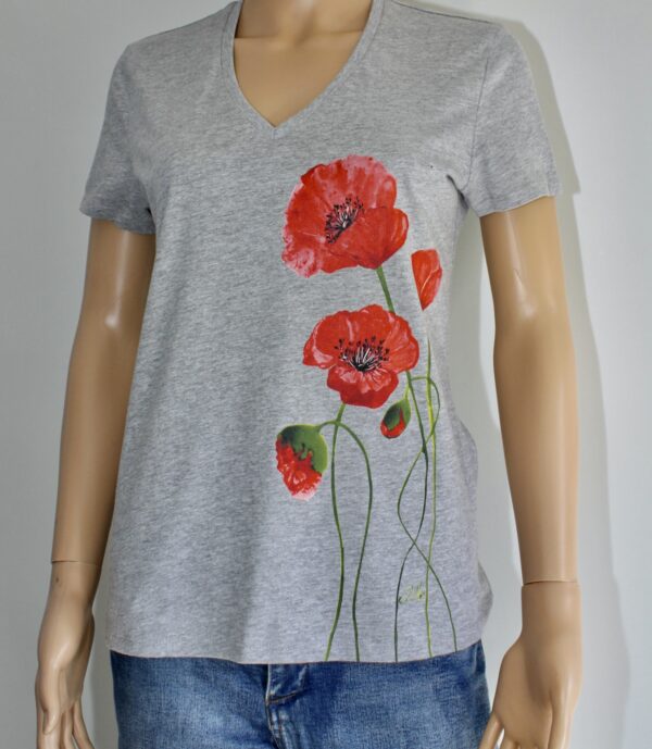 T-shirt gris à col V orné de motifs de coquelicots rouges sur le côté. Parfait pour un style floral et décontracté.